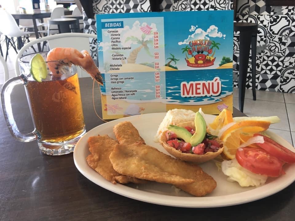 Platillo de filetes de pescado empanizados crujientes con arroz, ensalada de citricos y una cerveza Pacífico