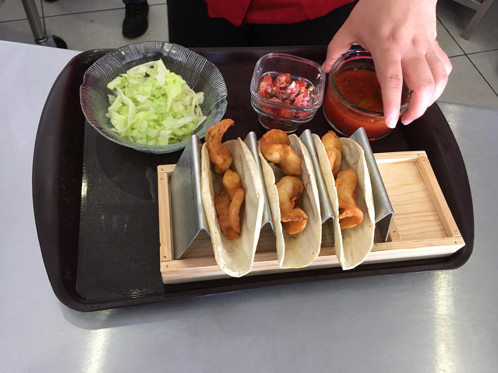 Tacos de mariscos capeados servidos en bases metalicas